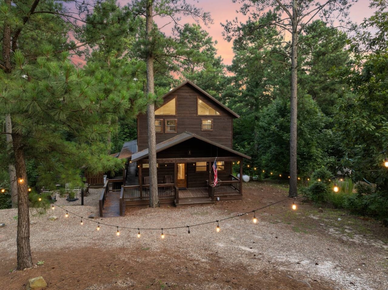 Exterior view with string lights leading toward the cabin entry.