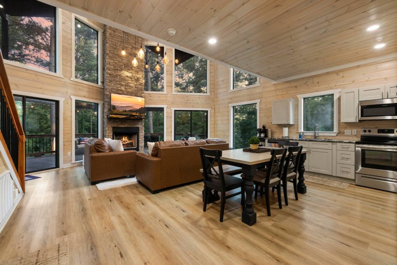 Wide main-floor view connecting kitchen, dining, living, and fireplace.