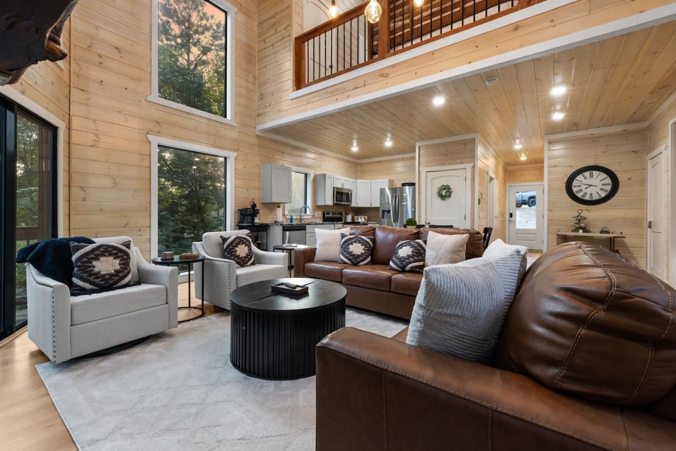 Great room sofa seating with fireplace and tall window wall.