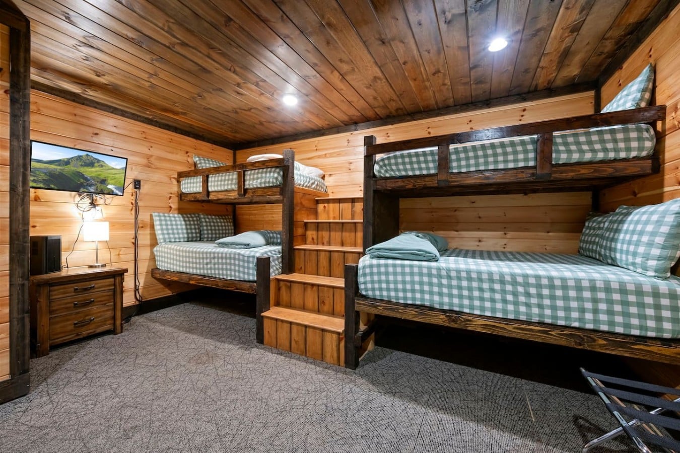 Bunk room with multiple beds, TV, and space for younger guests.