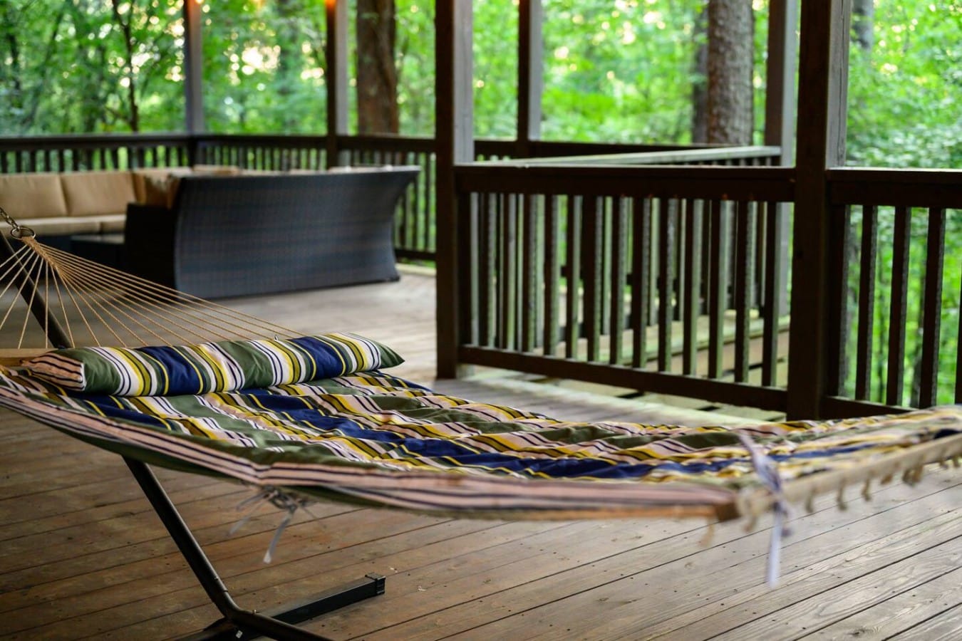 Hammock detail on the covered deck surrounded by pines.