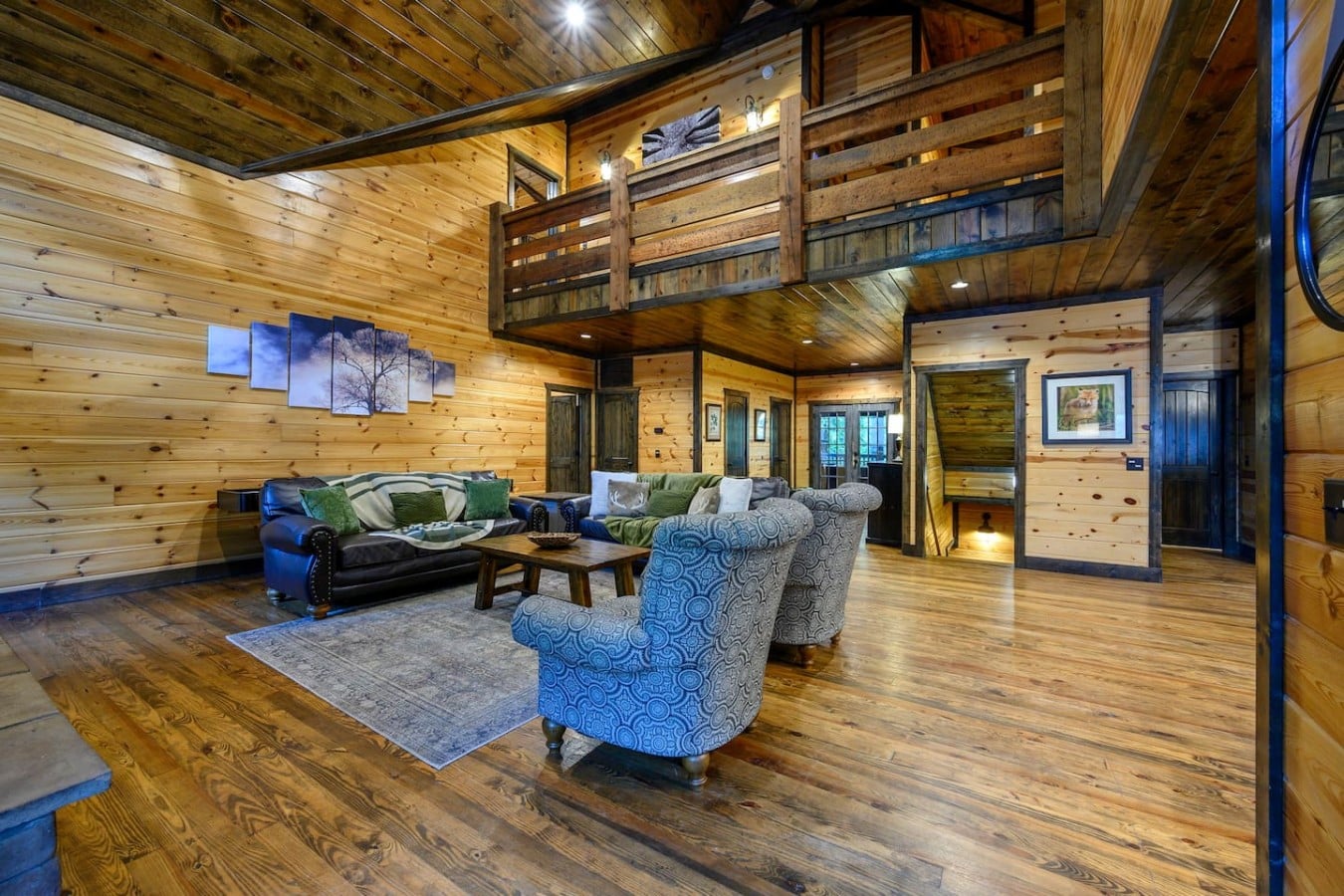 Main living area with high ceilings, fireplace, and loft overlook.