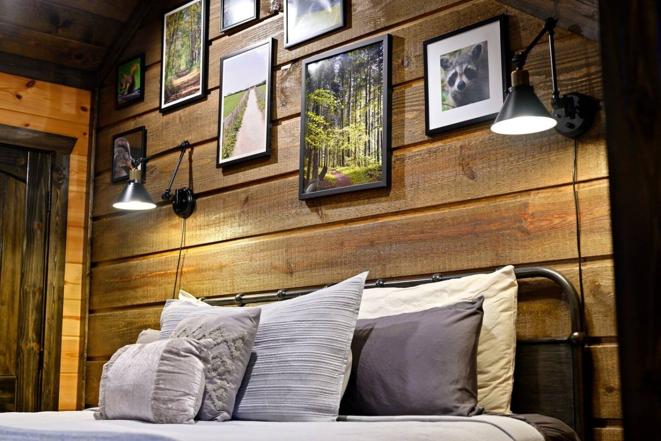 Bedroom headboard detail with gallery wall and reading lights.