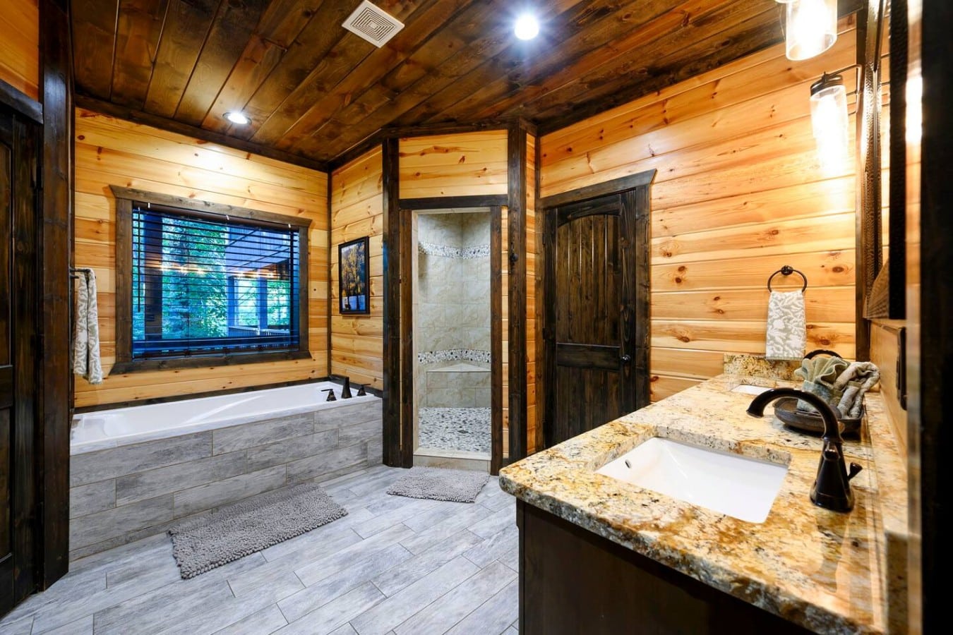Primary bathroom with soaking tub, vanity, and separate shower.