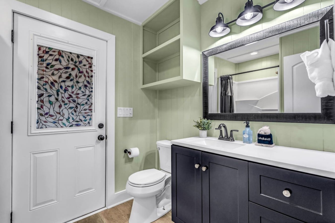 Get ready in style in this charming coastal bathroom with navy accents and warm lighting.