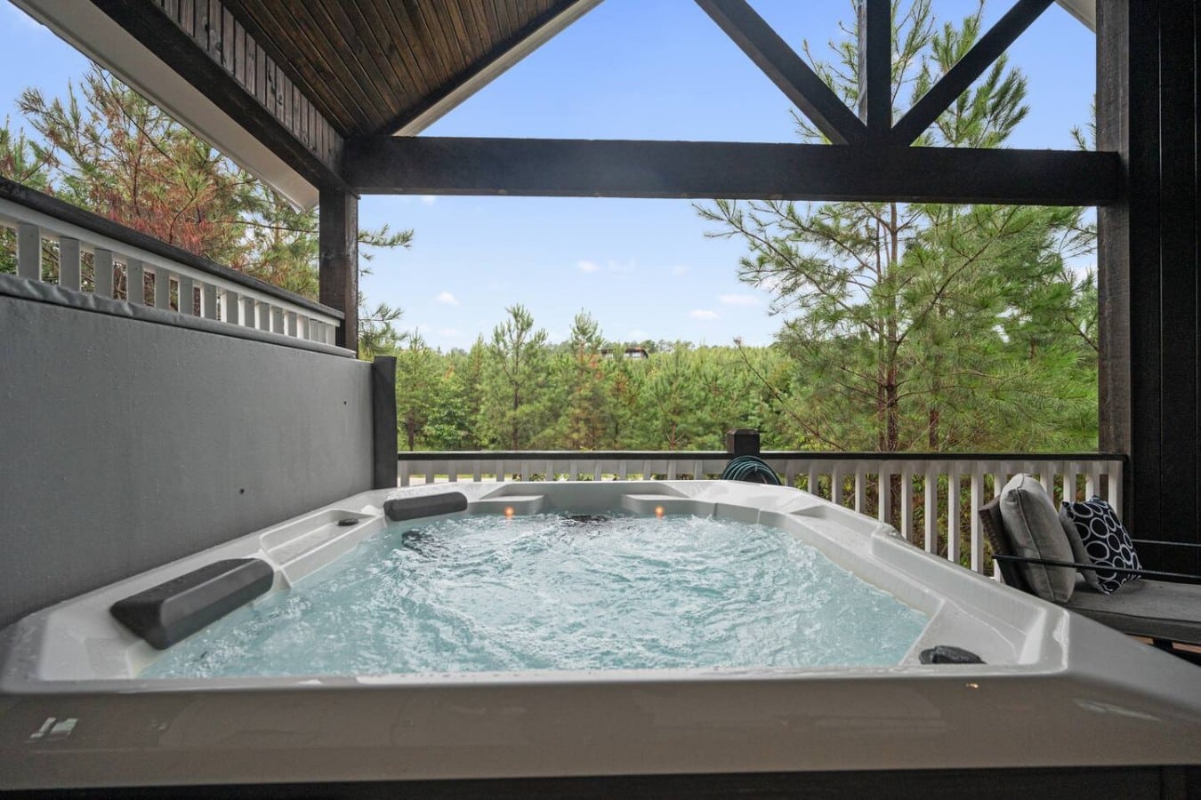 Bubble away in the treetop hot tub beneath dramatic timber beams and open blue skies.