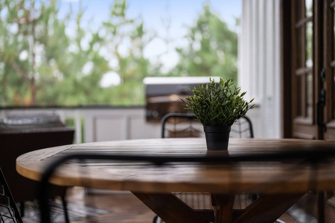 Alfresco dining feels special at a teak table nestled among the whispering pines.