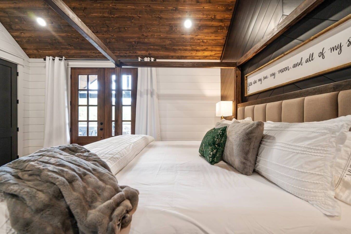 Wrap yourself in luxury linens and faux fur as vaulted ceilings soar above your king bed.
