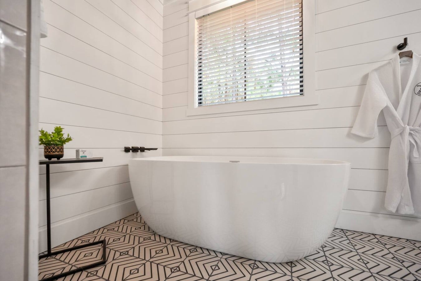 Indulge in a long soak in the freestanding tub while morning light fills this serene bathroom.
