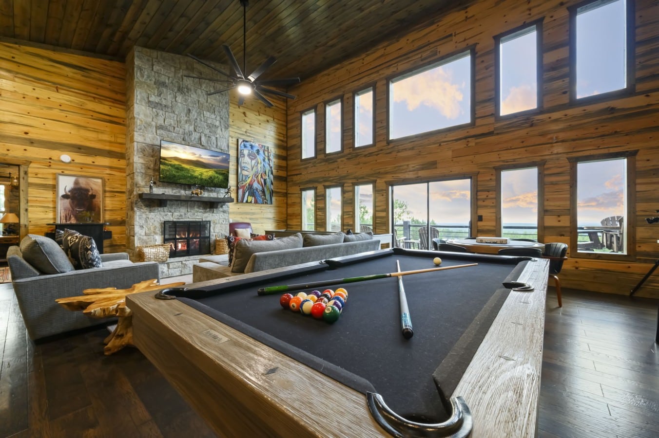 The pool table glows as the fireplace crackles and sunset colors flood the windows.