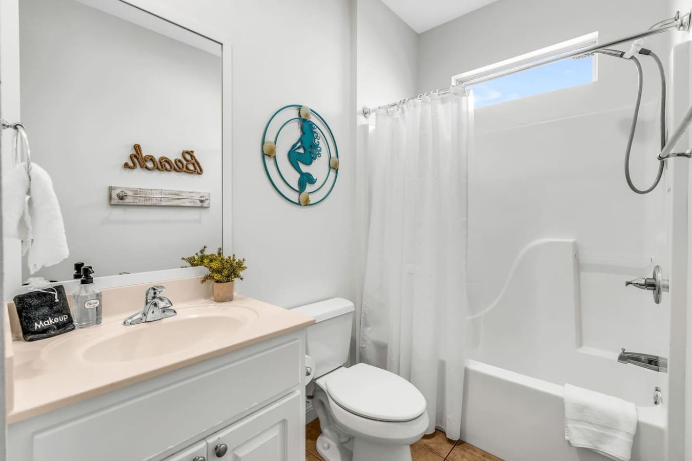 Mermaid vibes and natural light make this bathroom a cheerful start to every morning.