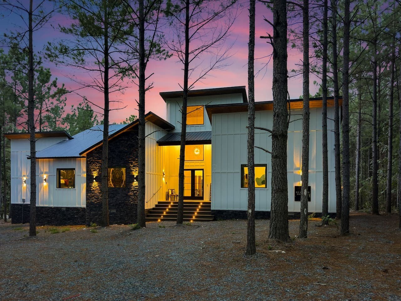 A pink-sky sunset frames this stunning modern farmhouse like a painting.