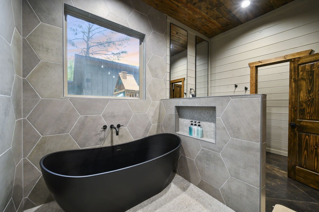 Reclaimed wood ceilings and a soaking tub turn the bath into a sanctuary.