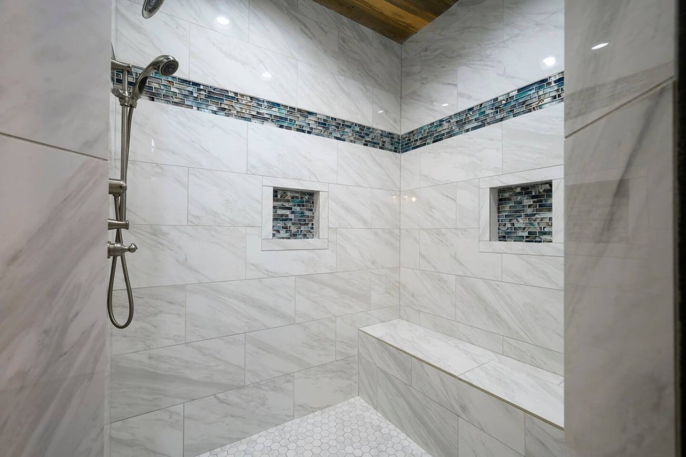 Rinse off in a spa-worthy shower with dual heads, a bench, and stunning tile work.