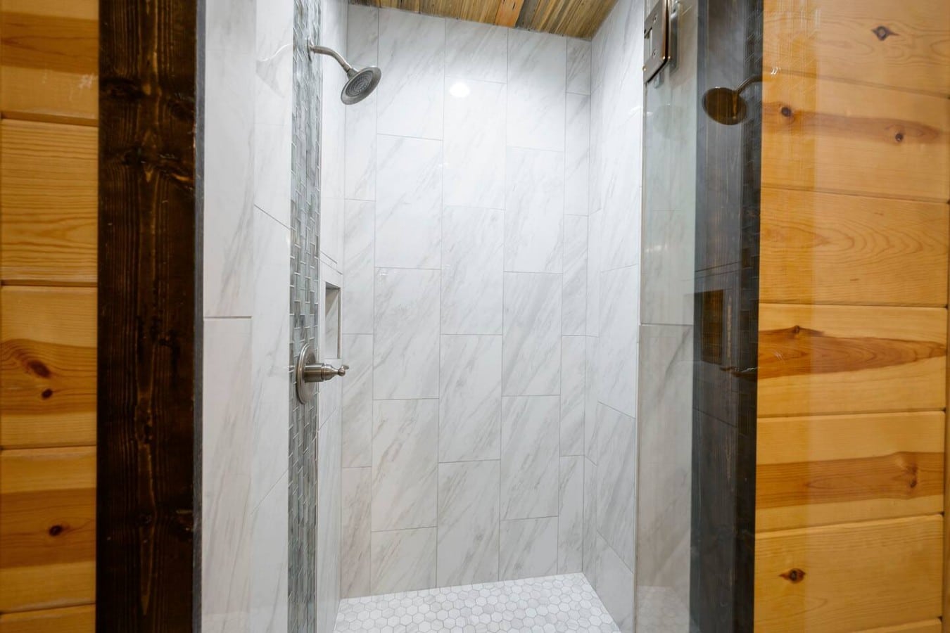 Hexagon floors and a rainfall head make this marble-tiled shower a daily luxury.