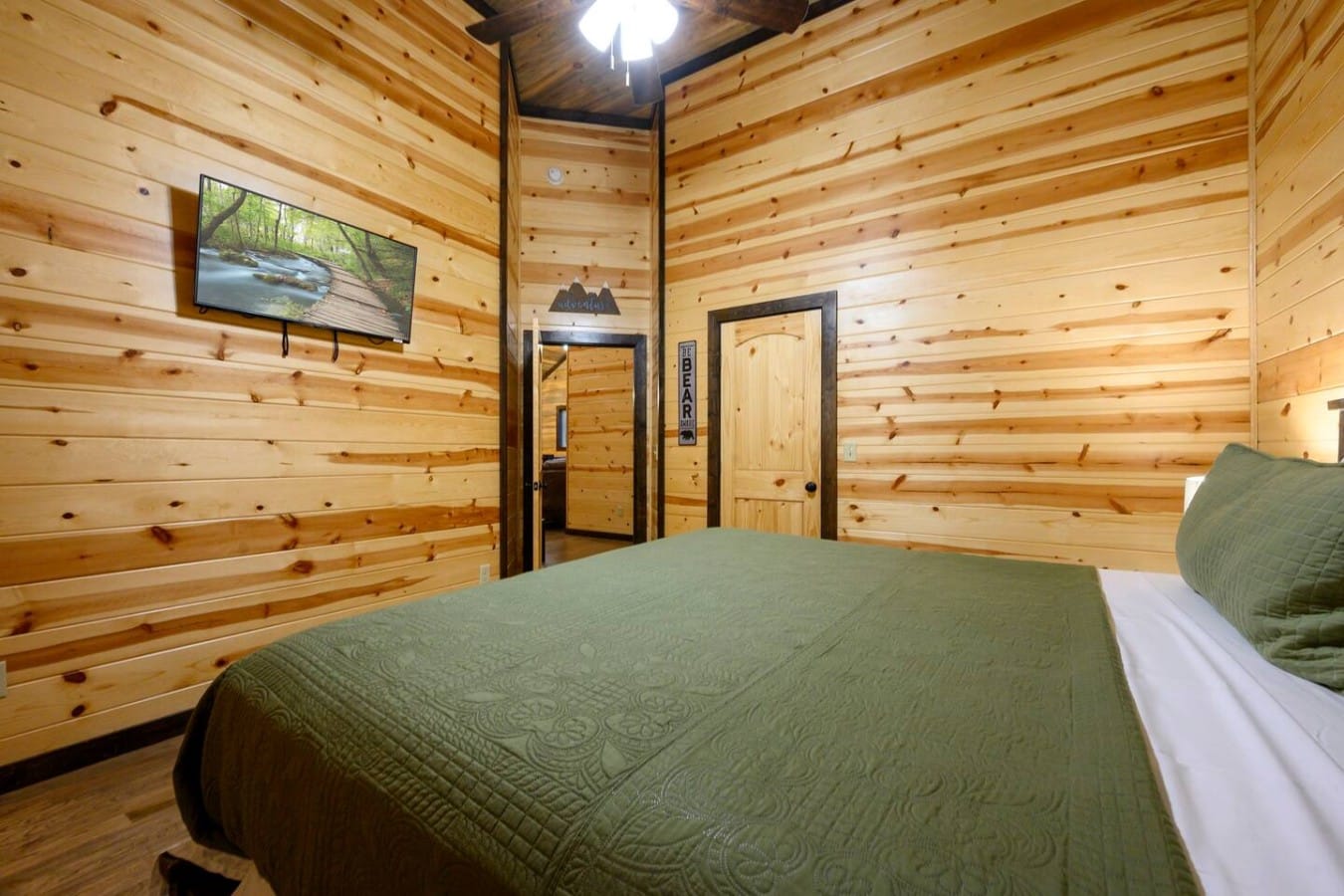Bear-themed touches and pine log walls make this cozy bedroom feel authentically rustic.