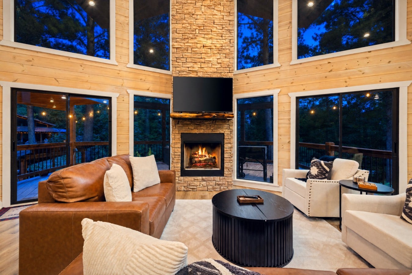 A blazing stone fireplace and panoramic windows make every evening feel cinematic.