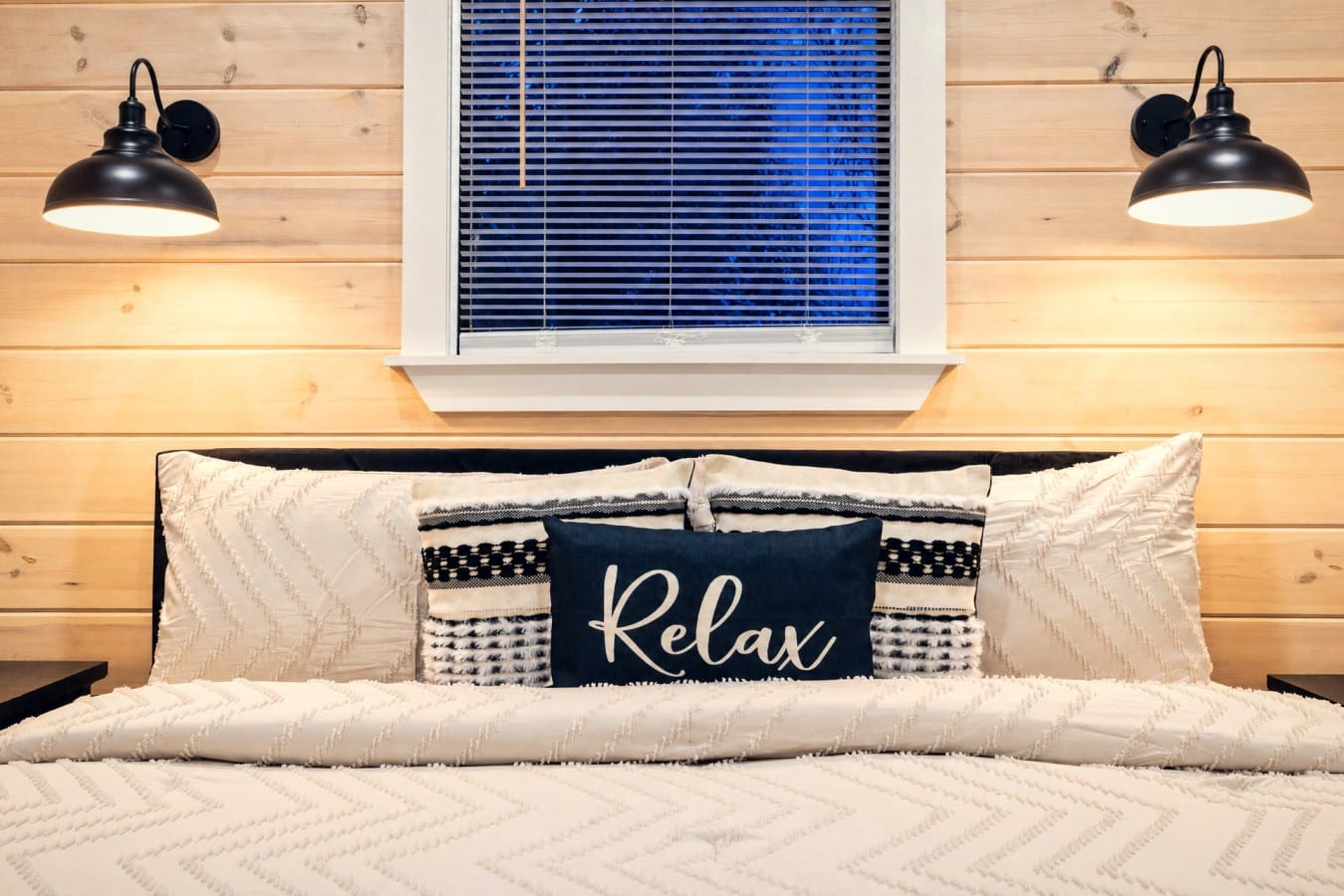 Sink into cloud-soft bedding and let barn-style sconces set the mood for total relaxation.