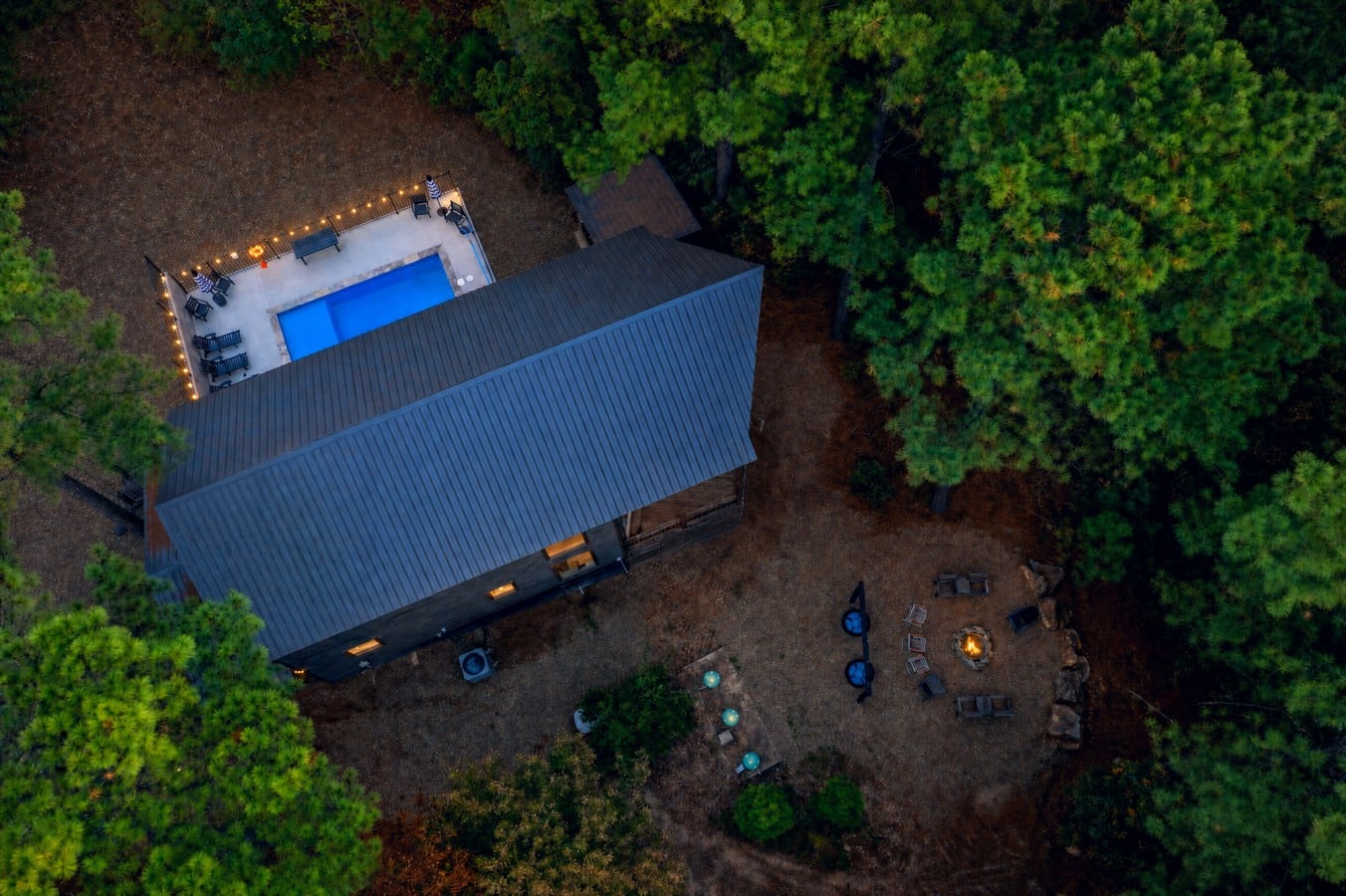 Fire pit, pool, and forest — this retreat has every evening covered.