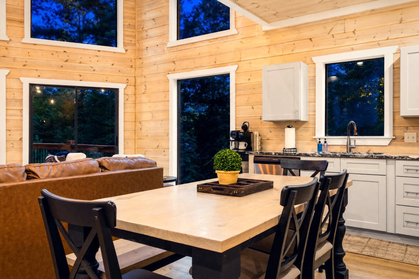 Gather around the farm table as forest twilight glows through floor-to-ceiling windows.