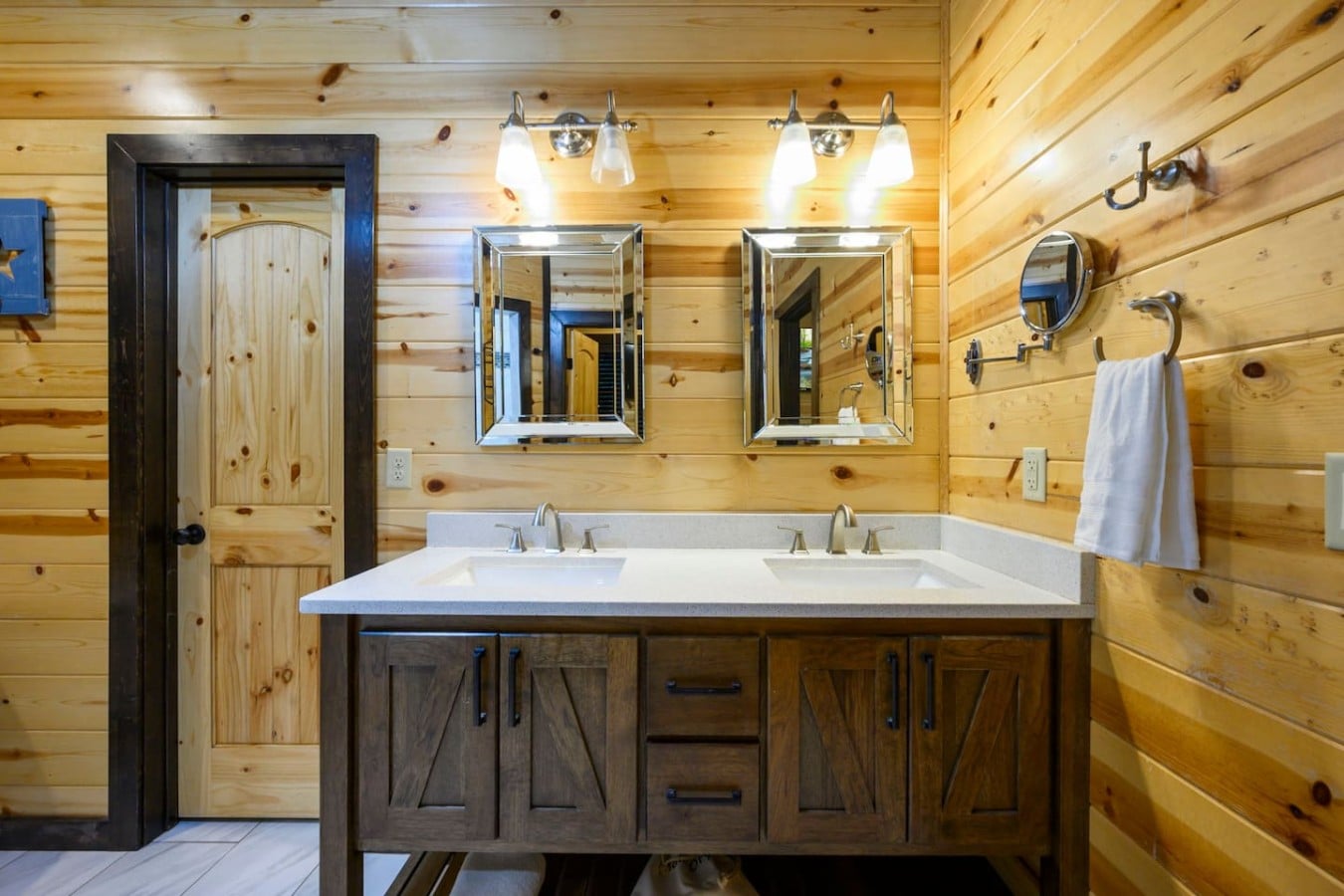 A double vanity and barn-style cabinetry give this bathroom practical cabin luxury.