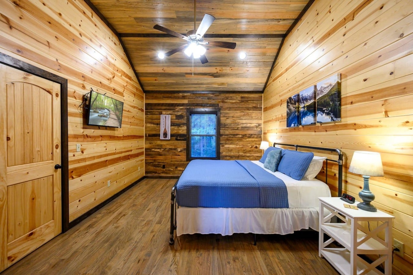 Vaulted pine ceilings and a reclaimed accent wall give this loft bedroom serious character.