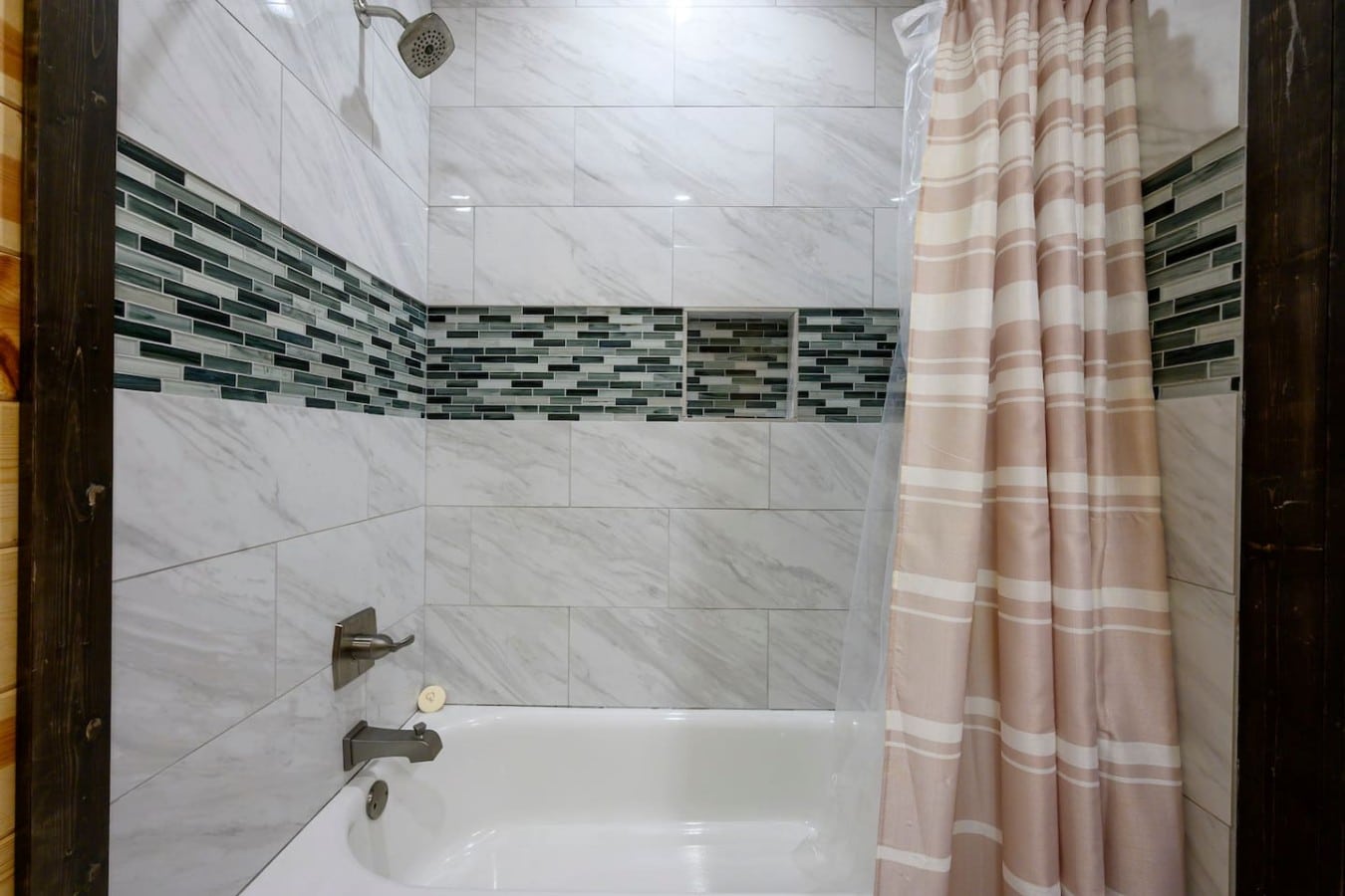 A marble-tiled tub-shower combo adds a spa-like touch to every morning routine.