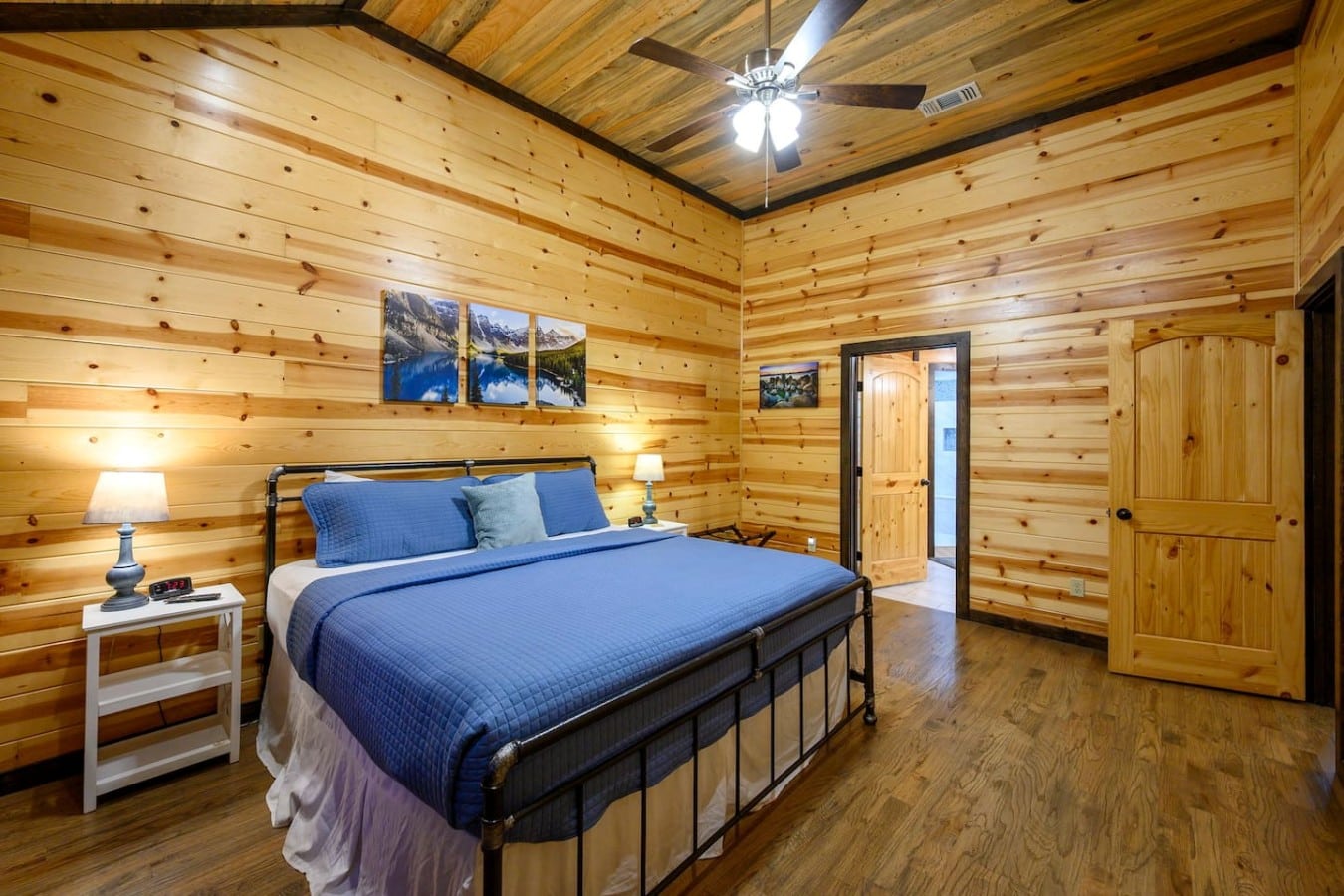 Mountain art and flanking lamps create a warm, inviting atmosphere in this king suite.