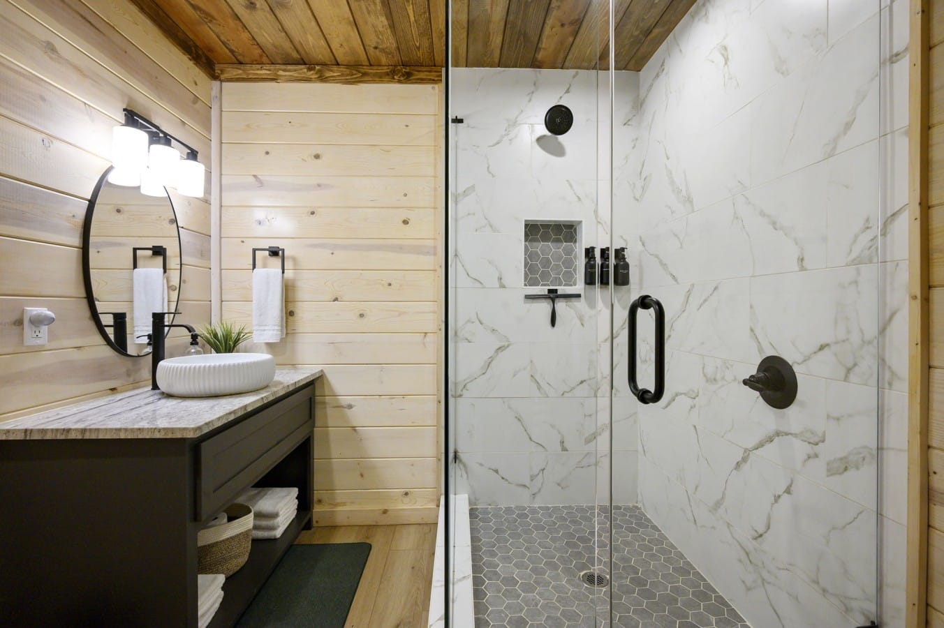 Marble-look tile and frameless glass give this master bath a true luxury hotel feel.