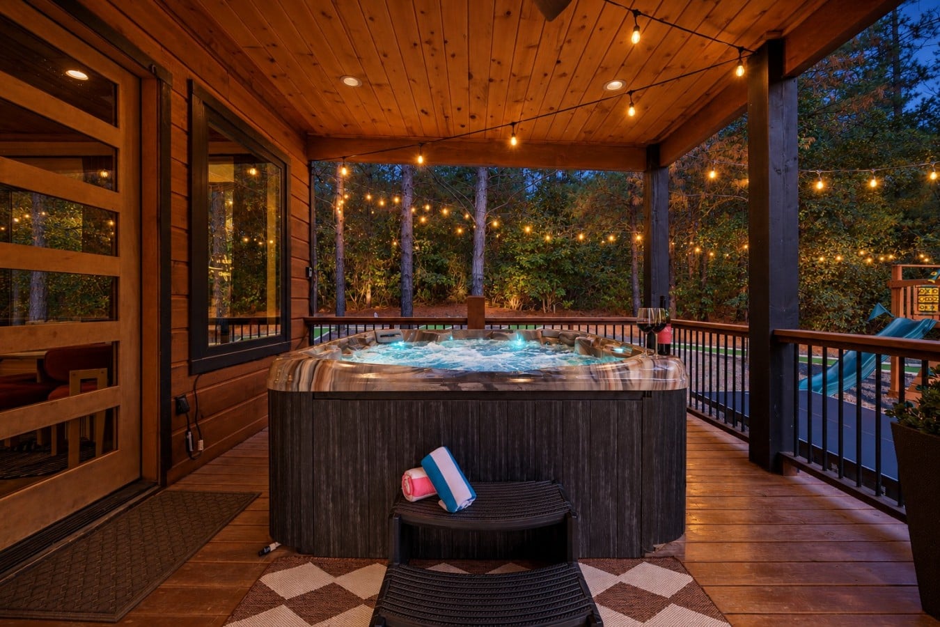 Red wine, bubbling jets, and bistro lights make this hot tub impossible to leave at twilight.