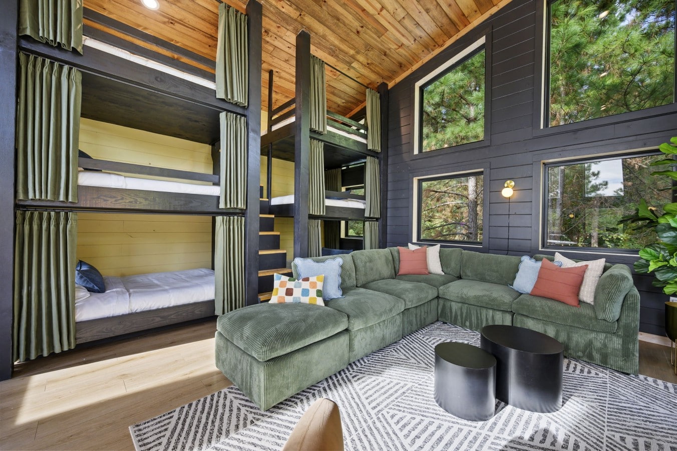 Queen-over-queen bunks with curtains plus a plush green sectional for movie marathons.
