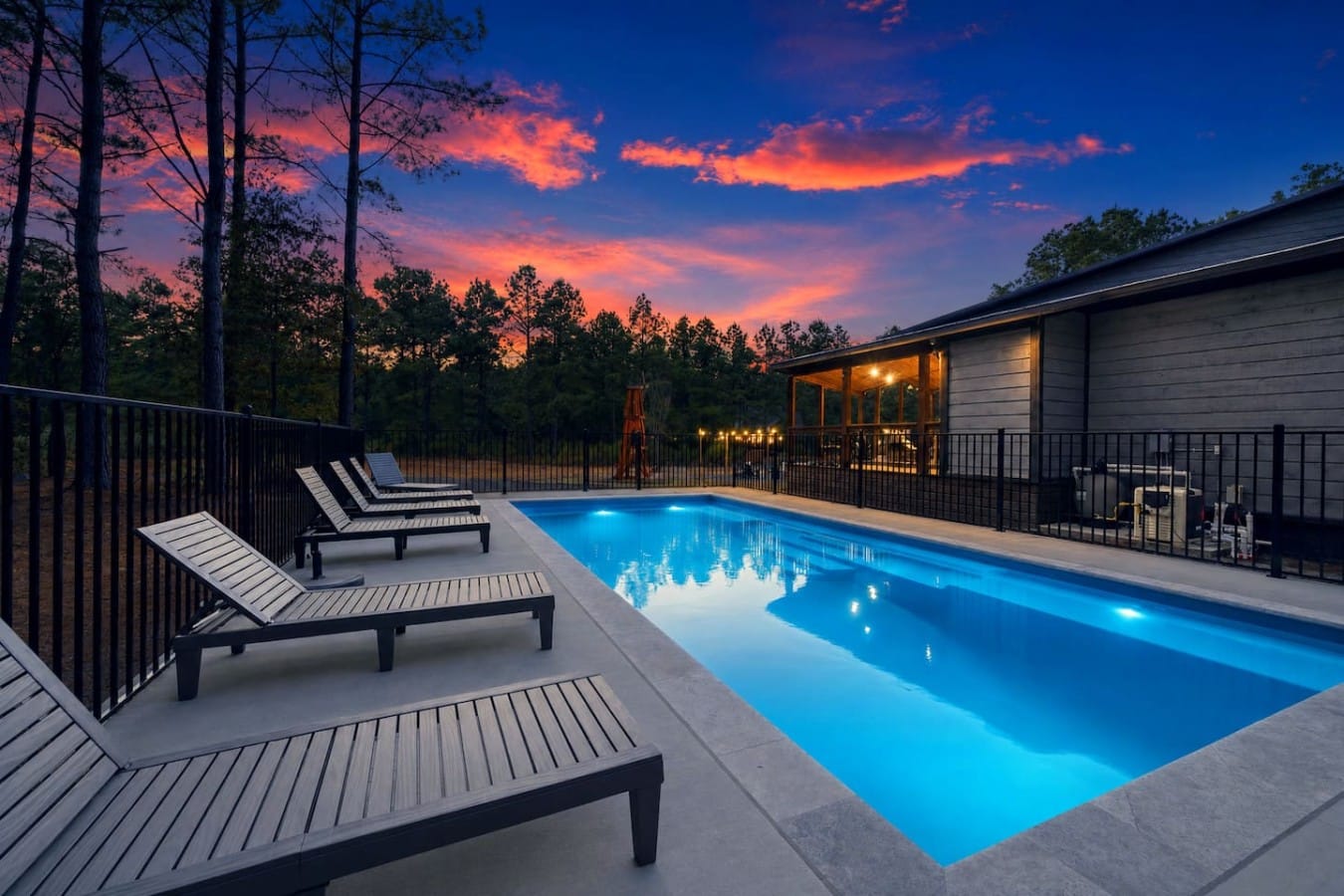 Lounge poolside as the sky erupts in color and the water glows electric blue.