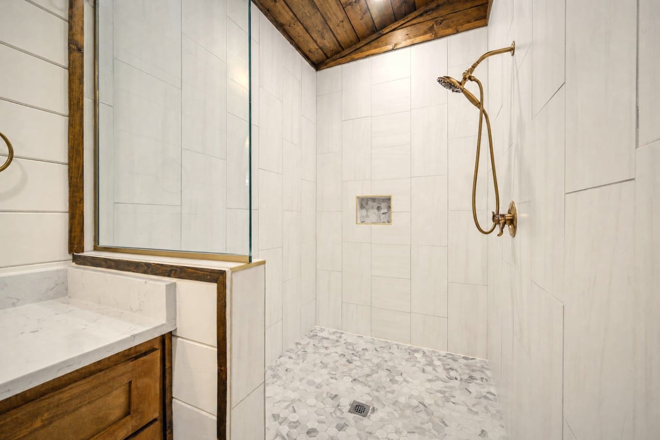 Gold fixtures and mosaic tile give the master bath a boutique-hotel feel.