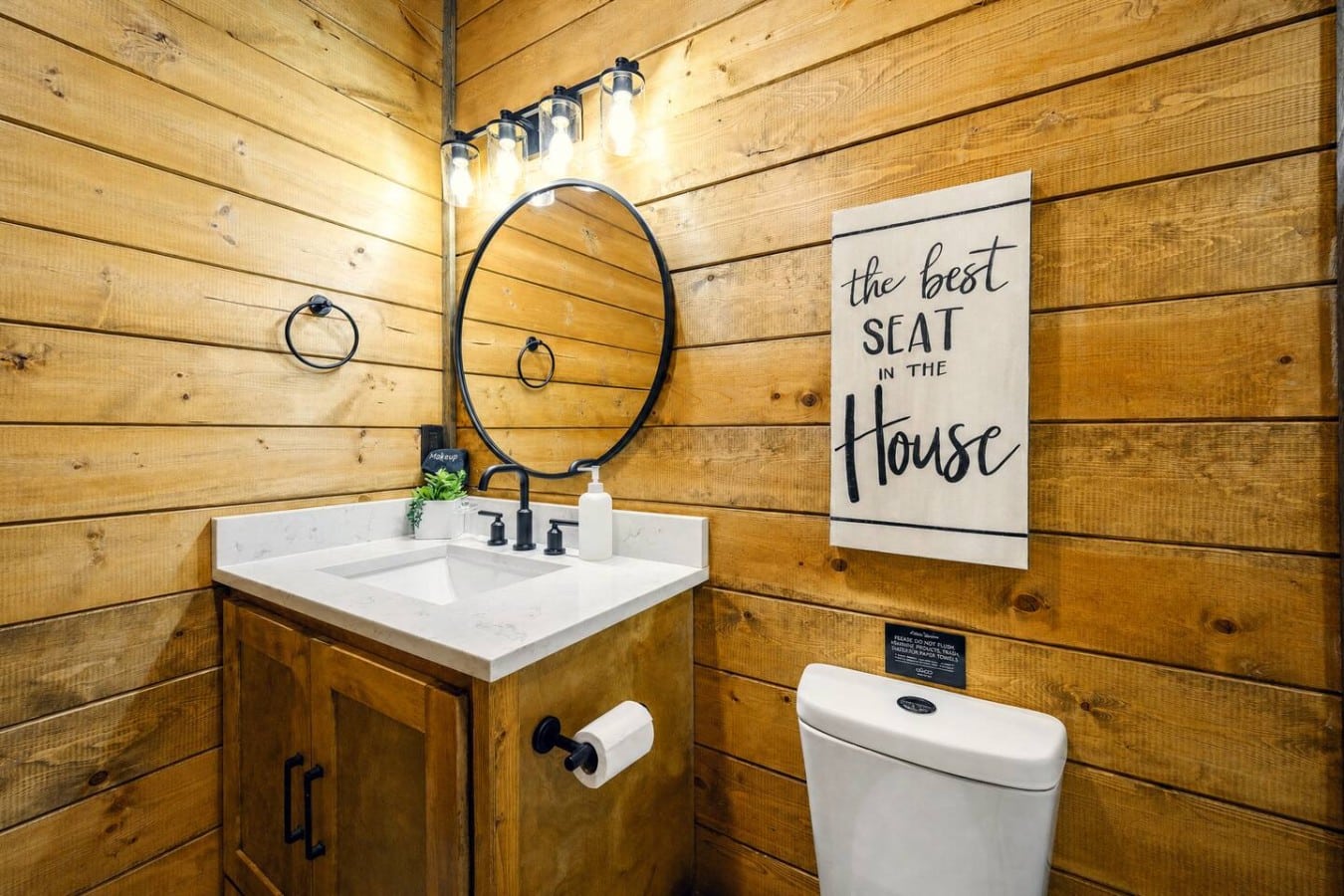 Even the half bath brings the cabin charm, right down to the cheeky towel sign.