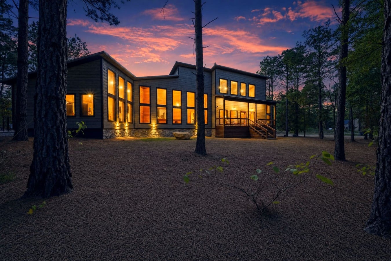 Warm golden light spills from every window into the cool pine-scented night.