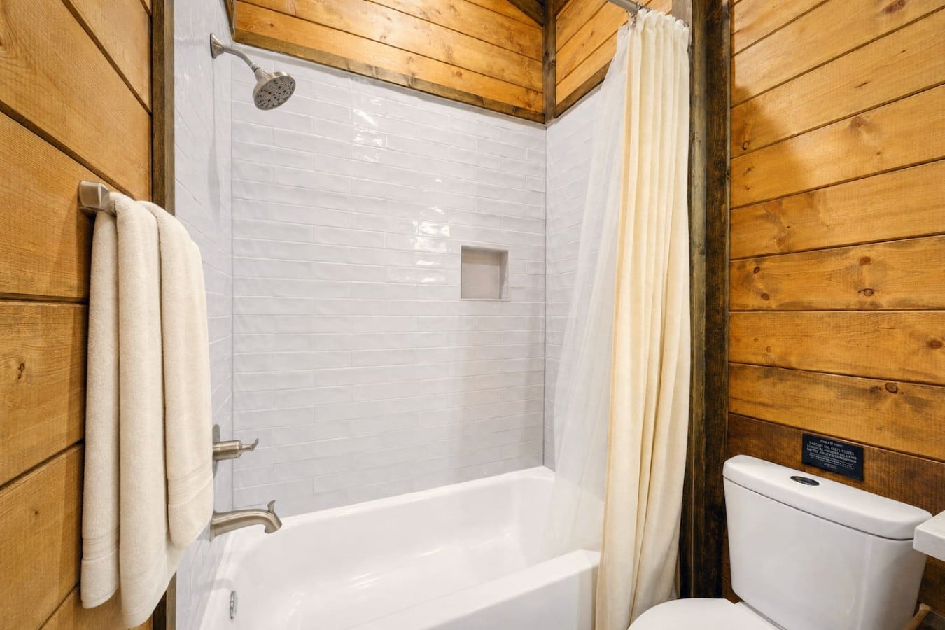 Pine-wrapped walls make even a quick rinse feel like a true cabin retreat.