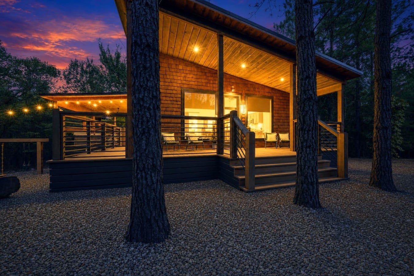 Tall pines frame this luminous cabin like a painting come to life at golden hour.