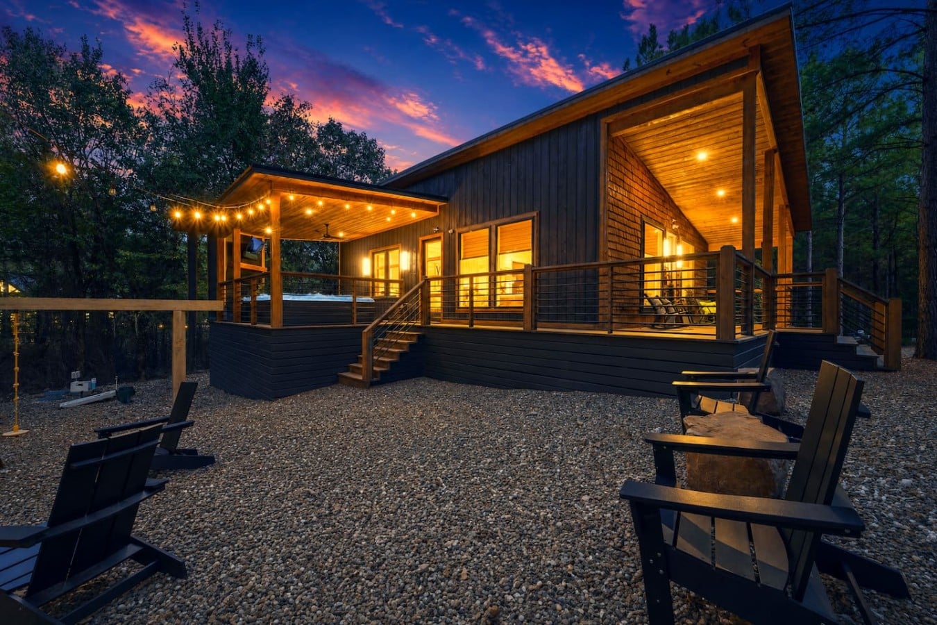 Every outdoor amenity—hot tub, fire pit, deck, and chairs—comes together under one glowing sky.