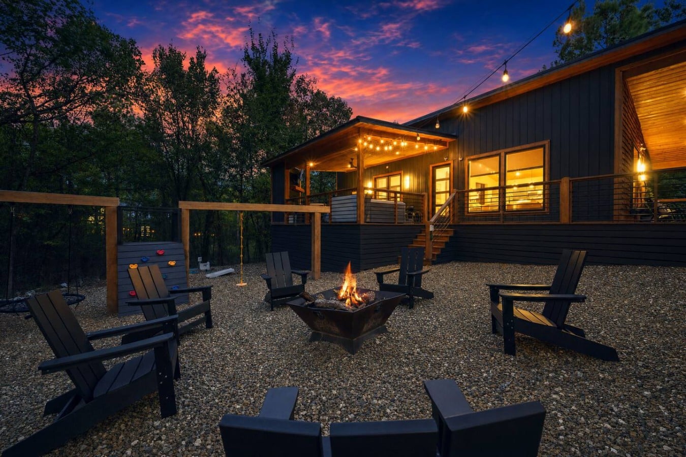 Gather around a crackling fire pit as the sky erupts in purple and gold above the trees.
