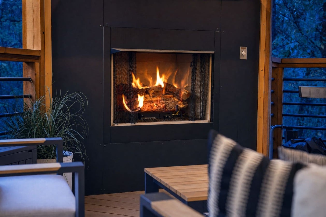A roaring fireplace sets the mood for cozy evenings on your covered outdoor lounge.