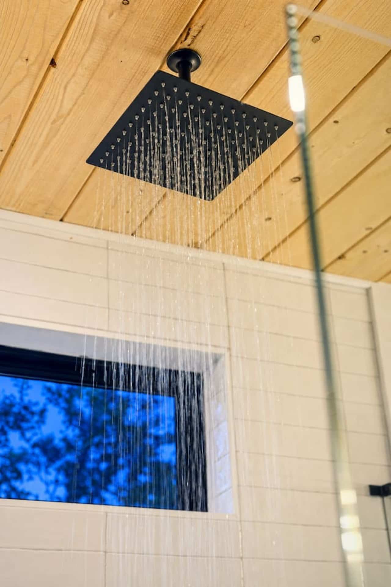 Start mornings refreshed under a rain shower with a private treetop view just outside.